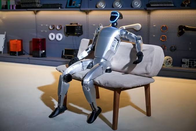Robô humanoide Unitree G1, modelo que a Robozin aluga para eventos, sentado em um sofá
