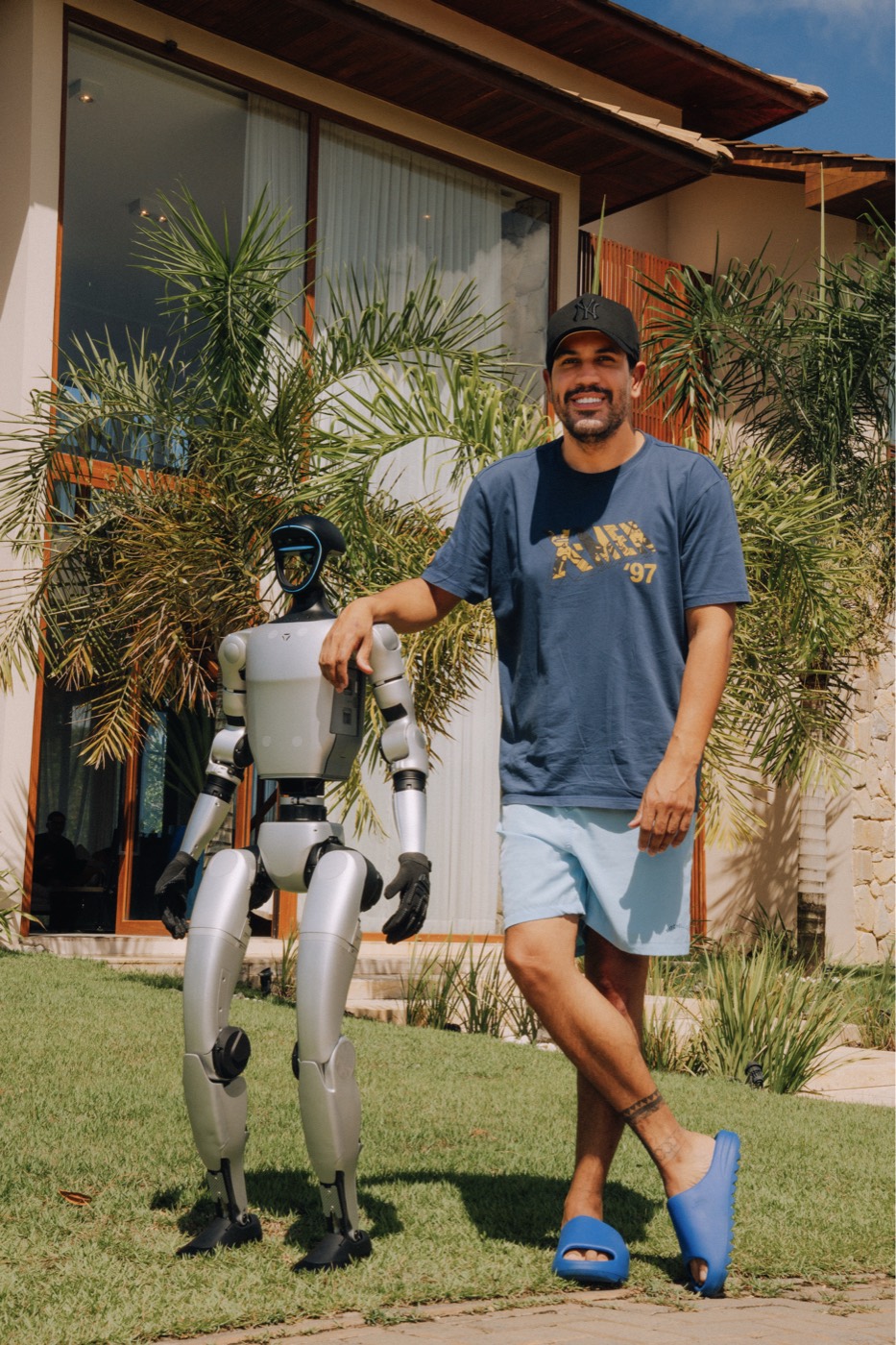 Robô humanoide Unitree G1 da Robozin em pé no jardim, ao lado do fundador Izaias Pertrelly